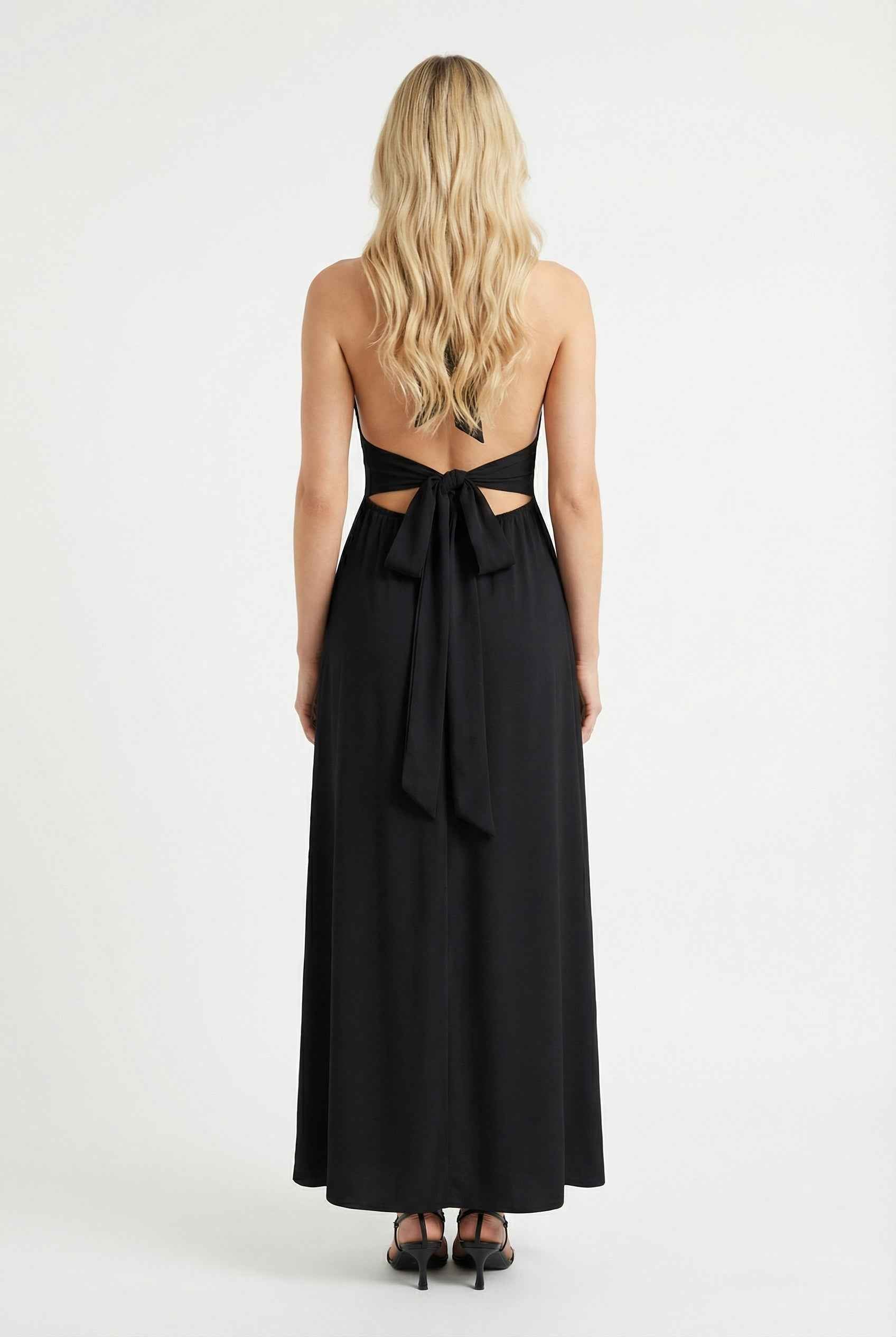 Elegant black halter neck dress by Lumina Wear, featuring a versatile fit and stylish design, shown on a model.