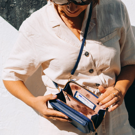 Elegant black leather clutch bag with versatile strap from Lumina Wear, featuring a sleek design perfect for evening and formal occasions.