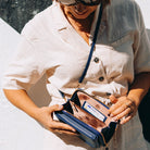 Elegant black leather clutch bag with versatile strap from Lumina Wear, featuring a sleek design perfect for evening and formal occasions.