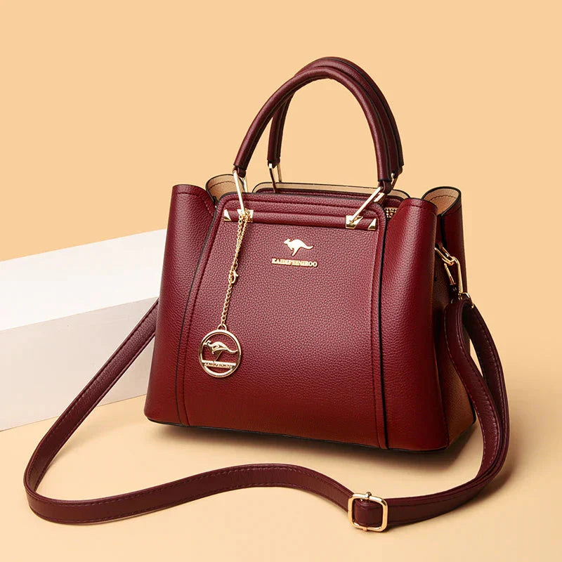 Elegant black leather handbag by Lumina Wear with gold accents, showcasing a sleek design and structured shape.