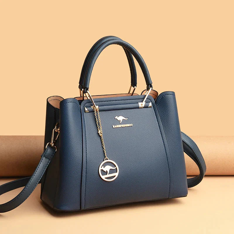 Elegant black leather handbag by Lumina Wear with gold accents, featuring a structured design and top handle for a sophisticated look.