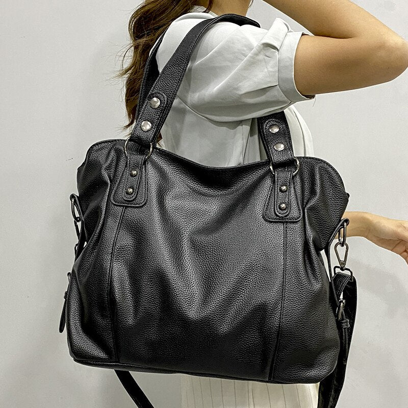 Elegant black synthetic leather tote bag by Lumina Wear featuring sleek design and spacious interior for versatile use.