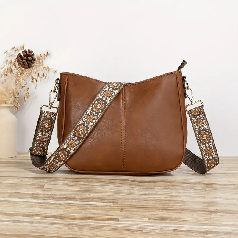 Elegant black vegan leather shoulder bag by Lumina Wear with adjustable strap, featuring a sleek design and spacious interior.