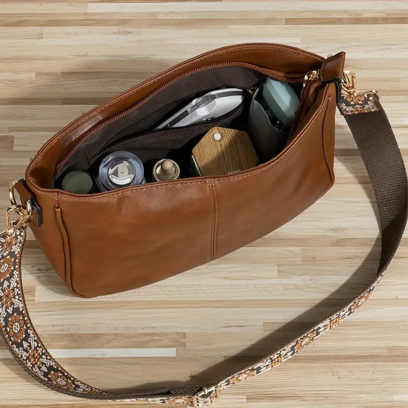 Elegant black vegan leather shoulder bag with adjustable strap from Lumina Wear, featuring a sleek design and spacious interior.
