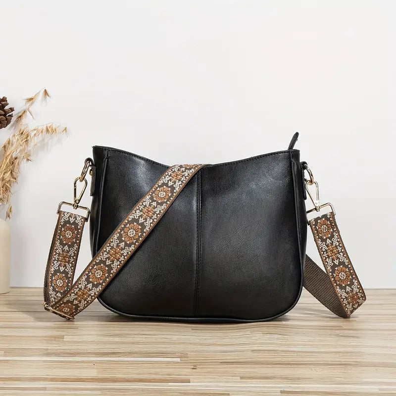 Elegant black vegan leather shoulder bag with adjustable strap from Lumina Wear, featuring a sleek design and spacious interior.