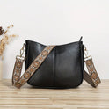 Black vegan leather shoulder handbag with adjustable strap from Lumina Wear, featuring a sleek, elegant design.