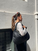 Elegant black vegan leather tote bag by Lumina Wear, Isabella handbag with spacious interior and sleek design.