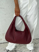 Elegant black vegan leather tote bag by Lumina Wear, featuring a spacious design and sturdy handles for versatile use.