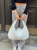 Elegant black vegan leather tote bag by Lumina Wear with structured design and top handles for versatile use.