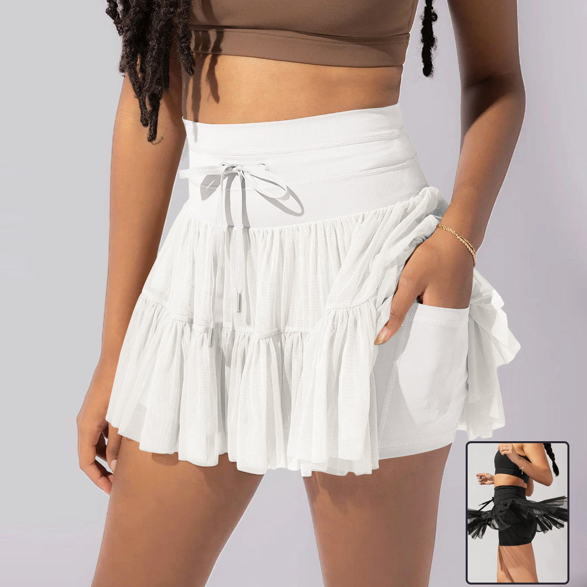 Light brown Isabella pleated mini skirt with integrated shorts by Lumina Wear, showcasing its elegant design and comfortable fit.