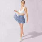 Light brown Isabella pleated mini skirt with integrated shorts from Lumina Wear, featuring a stylish, elegant design.