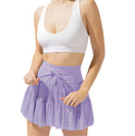 Light brown Isabella pleated mini skirt with integrated shorts from Lumina Wear, featuring a stylish, elegant design.