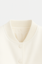 Isabella white bomber jacket by Lumina Wear featuring a sleek, elegant design and classic style, displayed on a hanger.