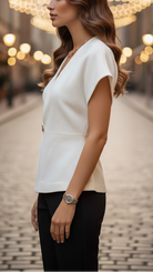 Ivory cap sleeve wrap blouse from Lumina Vancouver's Isabelle collection, displayed on a hanger.