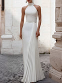 White Isabelle pleated halter-neck gown by Lumina Wear, elegant floor-length dress with a fitted waist and flowing skirt.