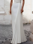 White Isabelle pleated halter-neck gown by Lumina Wear, elegant floor-length dress with a flowing silhouette.
