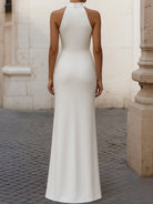 White Isabelle pleated halter-neck gown by Lumina Wear, showcasing elegant design and flowing fabric.