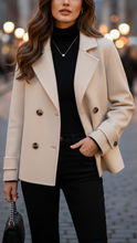 Ivory short double-breasted Lumina Wear jacket with lapels and buttons, displayed on a hanger.