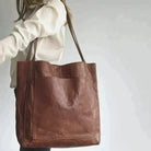 Elegant black leather handbag by Lumina Wear with spacious interior, featuring a structured design and durable leather material.
