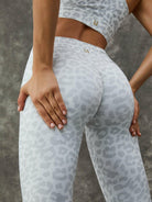 Leopard print Lumina Vancouver sports bra with zipper and stand collar, paired with white leggings, designed for active wear.
