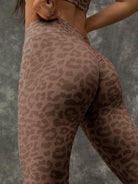 Leopard print Lumina Vancouver sports bra with zipper front and stand collar, shown with matching white leggings.