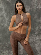Leopard print Lumina Vancouver sports bra with zipper and stand collar, paired with white leggings, designed for active wear.