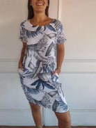 Lillian™ casual printed dress by Lumina Vancouver, white fabric with floral pattern, displayed on a hanger.