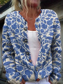 Lumina Wear Lowri flower print cardigan draped on a hanger, showcasing vibrant floral pattern and lightweight knit fabric.