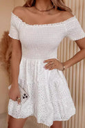 White Lumina Wear Luma off-shoulder mini dress with smocked bodice, showcasing a stylish and feminine design.