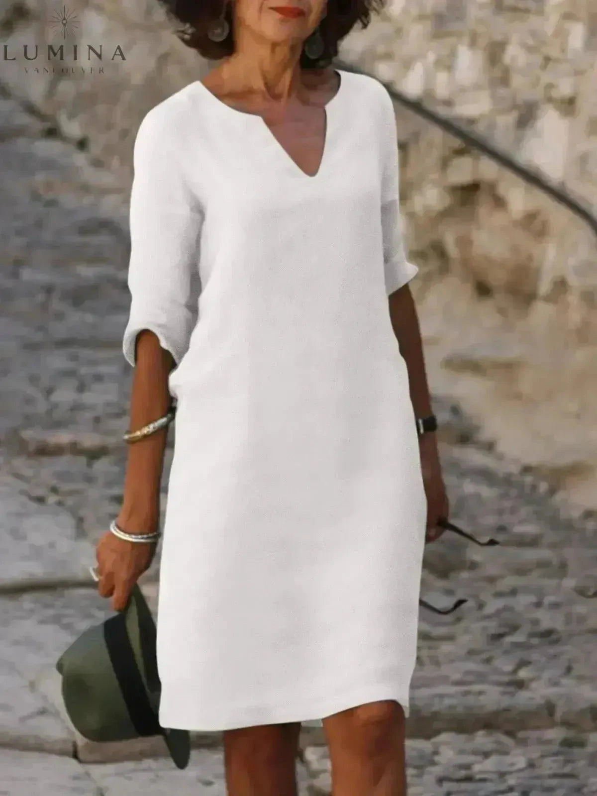 Black Lumina Vancouver Suzan elegant dress with V-neckline, displayed on a hanger against a neutral background.