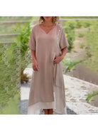Blue Lumina Vancouver Rosalie classic solid color maxi dress displayed on a hanger with flowing fabric and simple design.