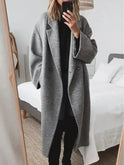 Grey Lumina Wear Kelly women's winter long coat hanging on a rack, showcasing its classic tailored design and cozy fabric.