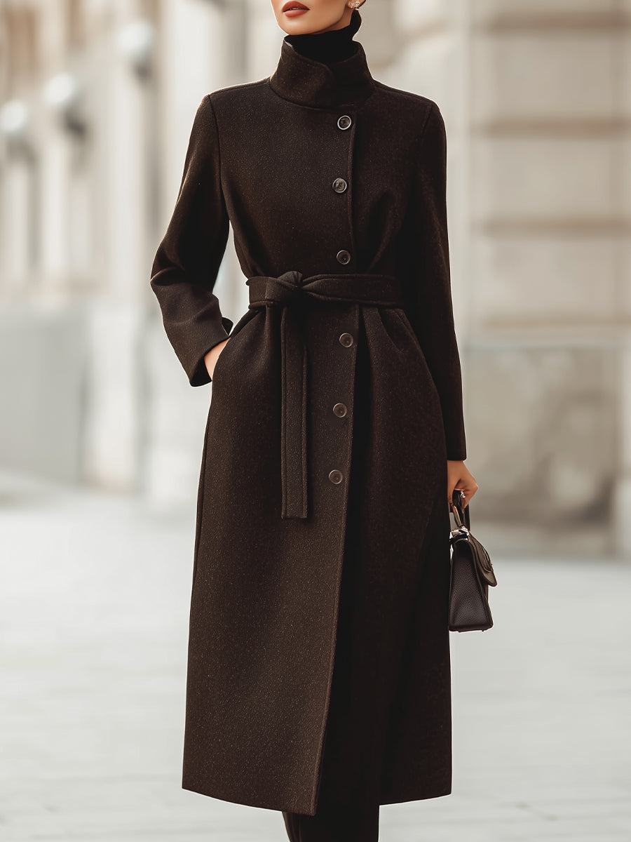 Brown Lumina Vancouver Georgie belted wool blend maxi coat hanging on a wooden hanger, showcasing its length and tailored fit.