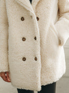 White Winifred double-breasted faux shearling coat by Lumina Vancouver, shown on a model with a cozy, stylish look.