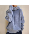 Sage green Zulema Comfort Sweater by Lumina Wear, cozy knit sweater with a relaxed fit and ribbed cuffs, displayed on a hanger.