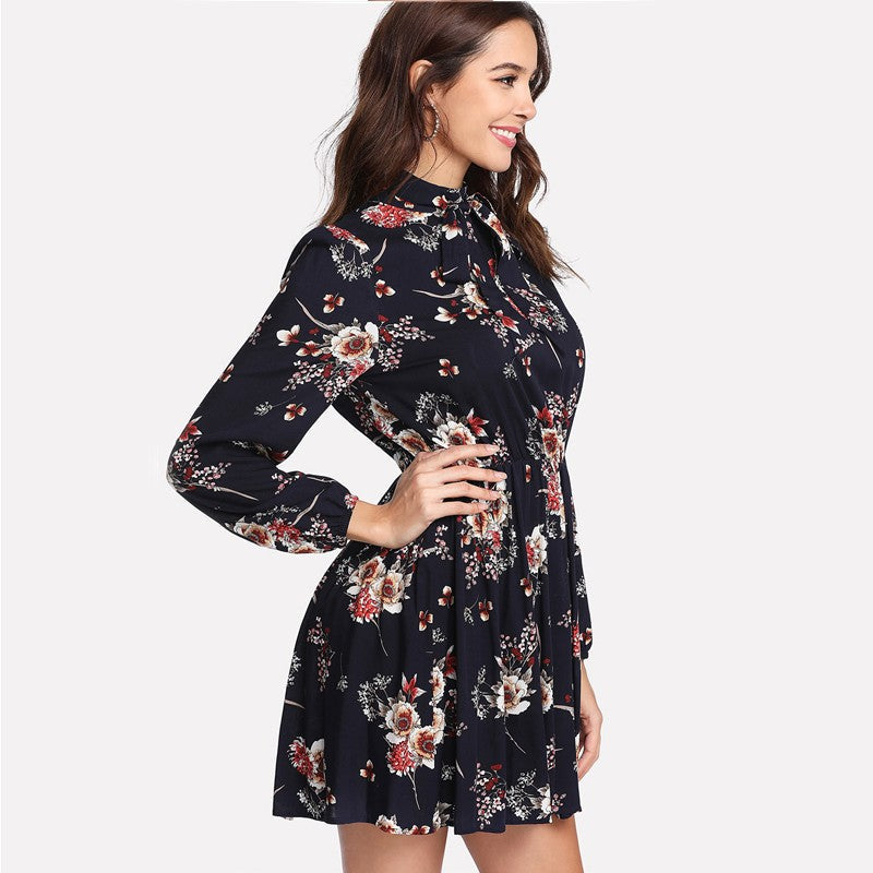 Dark blue Lumina Vancouver mini floral dress featuring a Bloom Meadow floral pattern, styled with a relaxed fit and short sleeves.