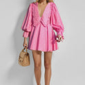 Pink Astra mini dress by Lumina Wear featuring cotton fabric, V-neckline, and gingham pattern, displayed flat on a neutral background.