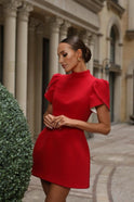 Red Lumina Wear Nova mini dress with tailored fit, open back, and bow detail, shown on a model.