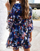 White women's floral V-neck mini dress by Lumina Vancouver, featuring a fitted style and lightweight fabric.