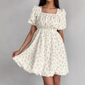 Seraphina floral mini A-line dress by Lumina Wear, white with colorful flower patterns, sleeveless and stylish for warm weather.