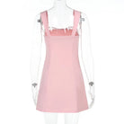 Pink satin mini dress with lace trim by Lumina Vancouver, showcased on a hanger with detailed lace accents and smooth fabric.