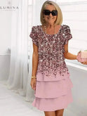 Lumina Wear Giselle floral dress displayed on a hanger, featuring a white background with colorful floral patterns and a flowing design.