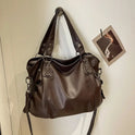 Lumina Wear Lunelle black handbag with spacious interior and versatile strap, shown with chocolate accents.