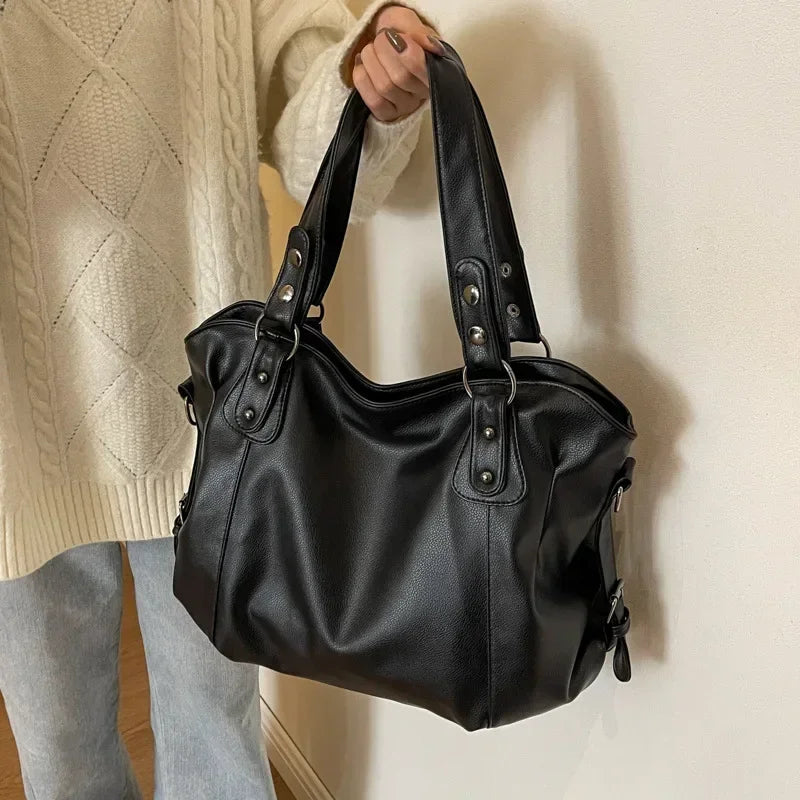 Lumina Wear Lunelle spacious black handbag with versatile strap, shown with chocolate accents and multiple compartments.