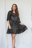 Light apricot Lumina Lyra loose-fit tiered mini dress shown on a hanger, featuring a relaxed silhouette and tiered design.