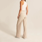 Cream high-waisted wide-leg trousers for women by Lumina Wear, featuring a chic, relaxed fit and elegant silhouette.