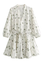 White and green Marin Willow wrap dress with V-neck by Lumina Vancouver, displayed on a model in a mini dress style.