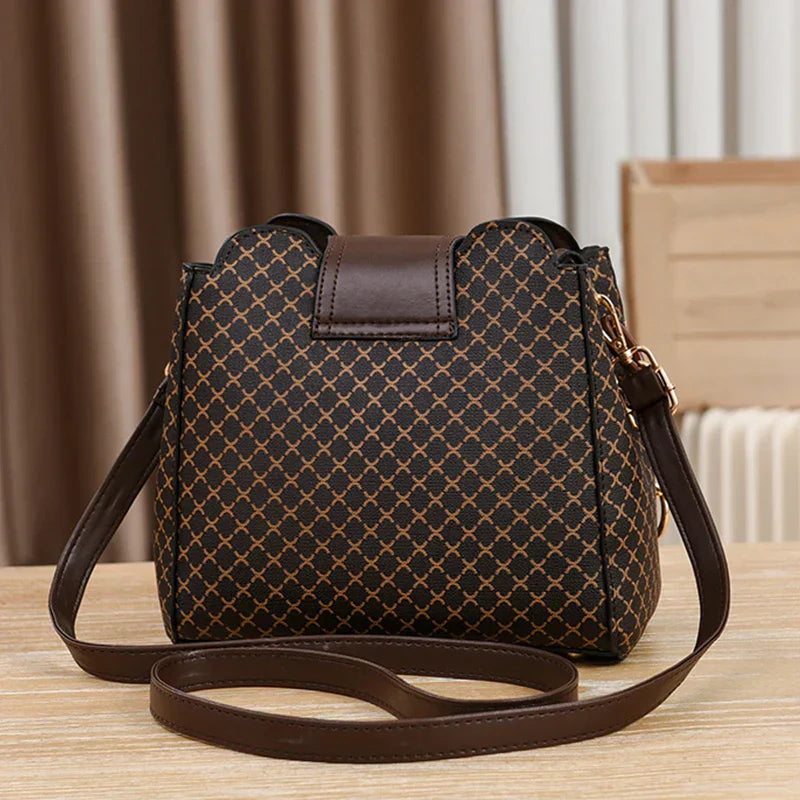 Black Marjorie quilted charm handbag with adjustable strap by Lumina Wear, featuring elegant stitching and compact design.