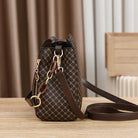 Black Marjorie quilted charm handbag with adjustable strap by Lumina Wear, featuring elegant stitching and compact design.