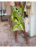 Vibrant coral pink abstract print dress by Lumina Wear, featuring a flowing design and bold artistic patterns.